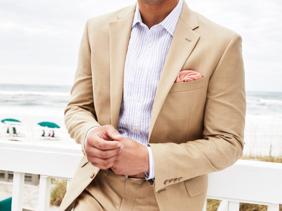 man wearing a tan suit at beach