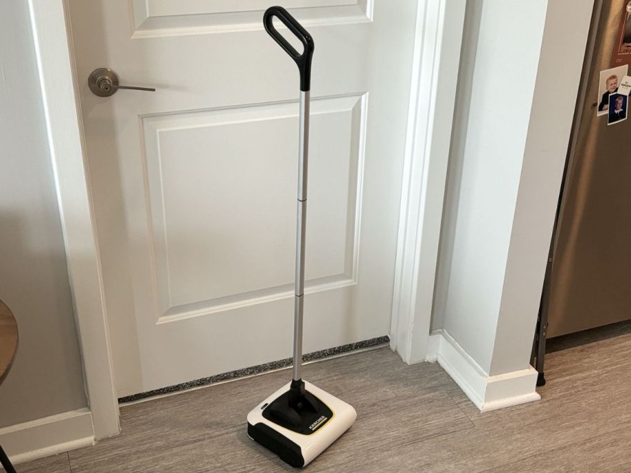 A Karcher Cordless Broom in front of a door