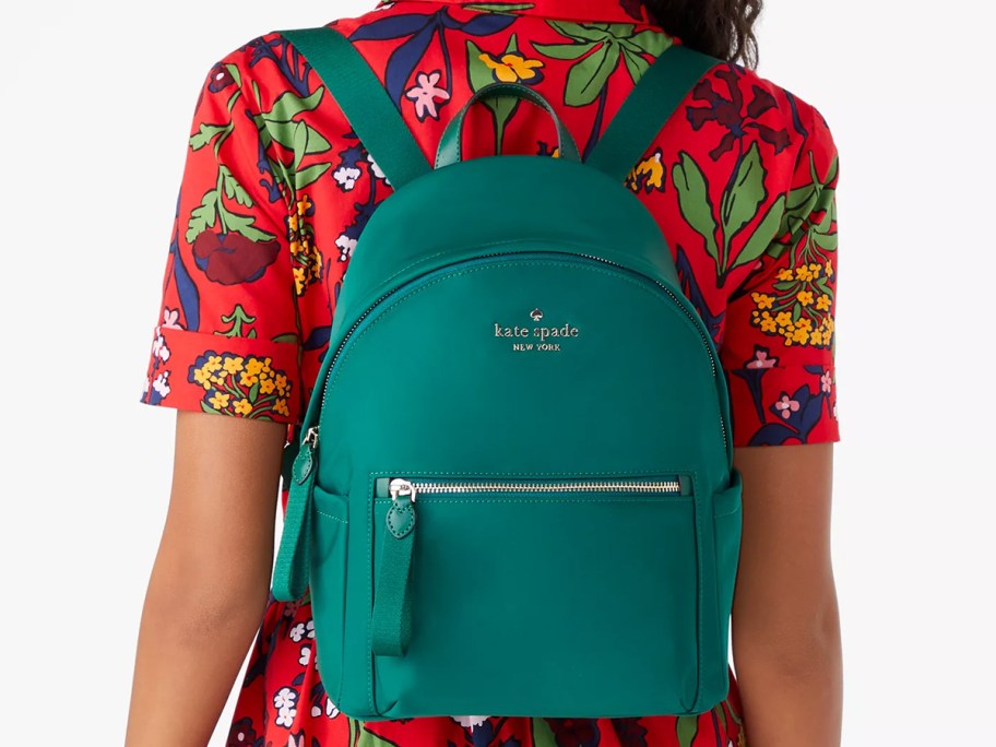 woman in a red dress with a green mini backpack