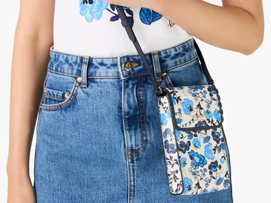 woman in a denim skirt with a white and blue floral print crossbody