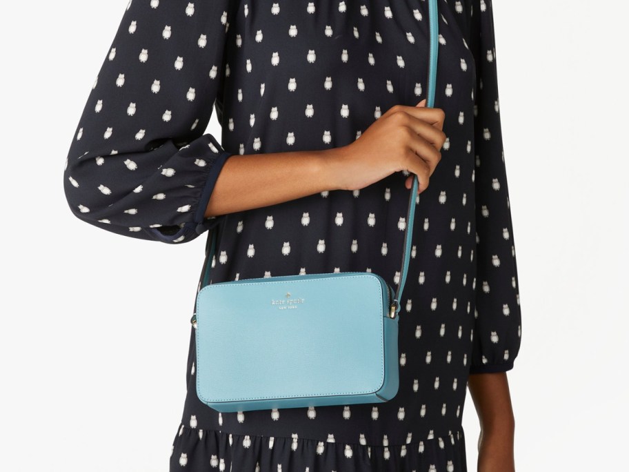 woman in black dress with blue crossbody bag