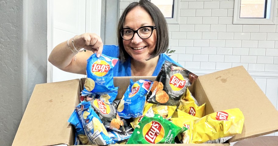 woman holding up a variety pack box of lays chips