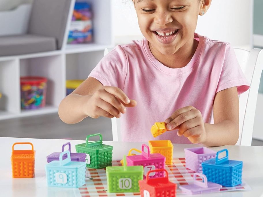 Little girl playing with Learning Resources Sorting Surprise Picnic Baskets