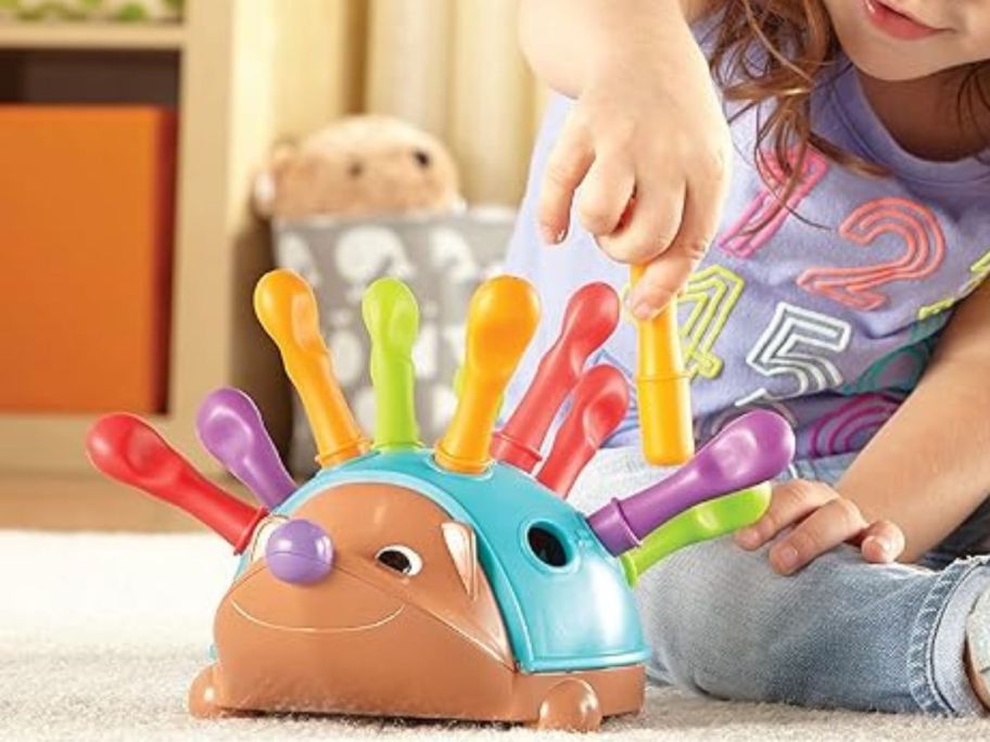 girl playing with Learning Resources Spike The Fine Motor Hedgehog
