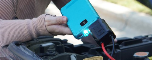 jump starting a car with a blue power bank