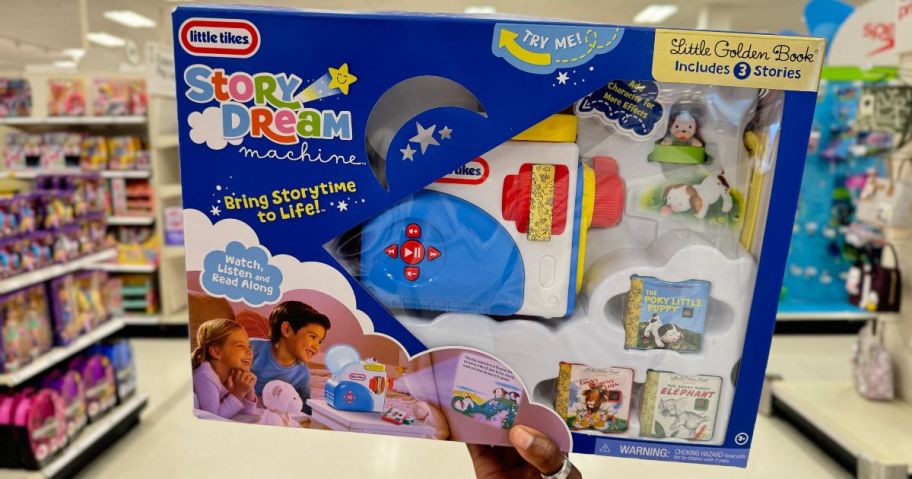 Little Tikes Story Dream Machine box being held by hand in aisle in store