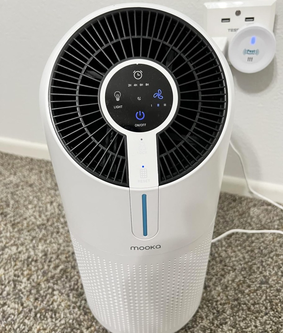 white and black air purifier sitting on carpet