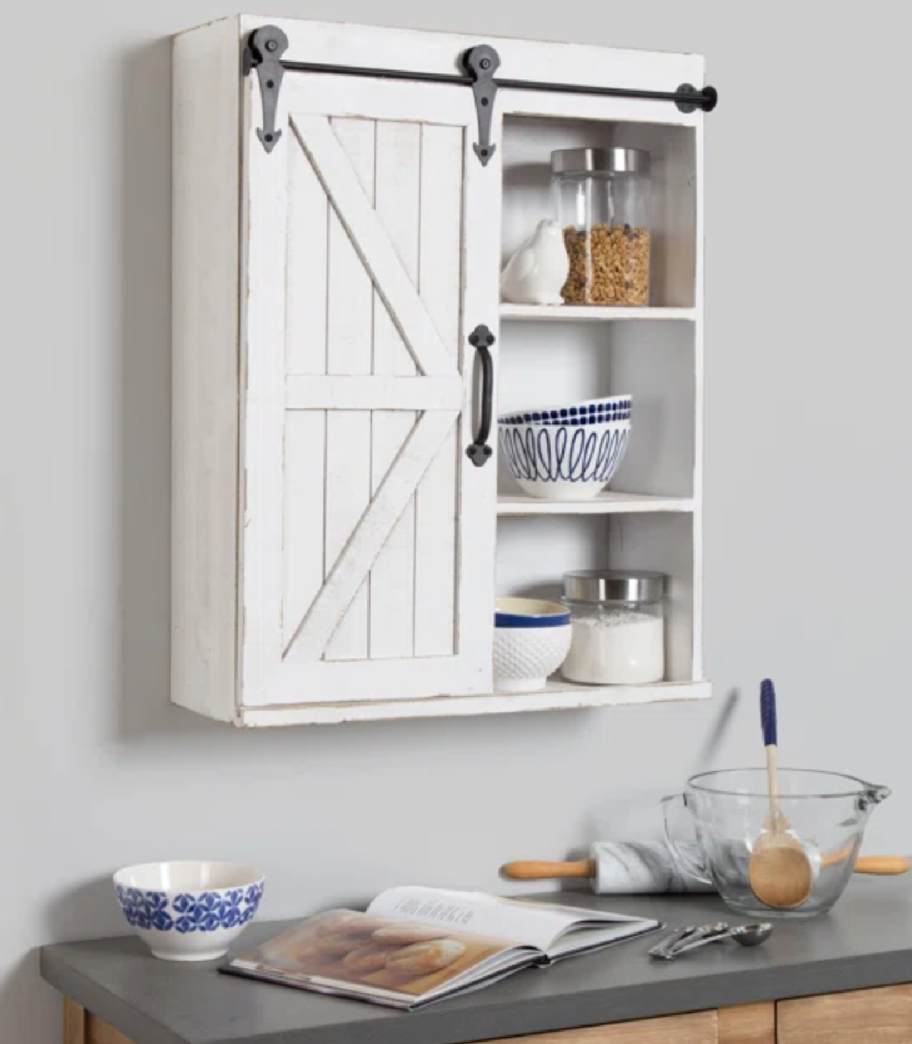 A white Malese cabinet hanging above a cooking space