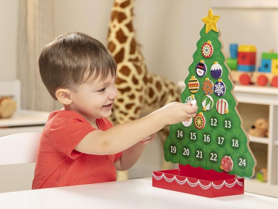 kid playing with Melissa & Doug Countdown to Christmas Wooden Advent Calendar