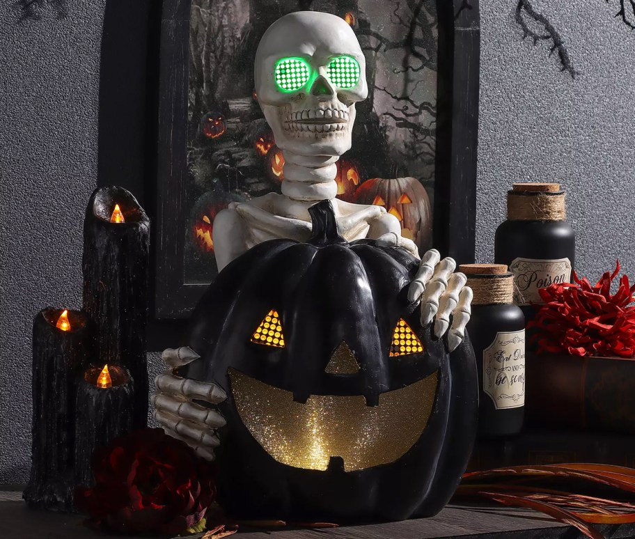 skeleton with green eyes holding black pumpkin