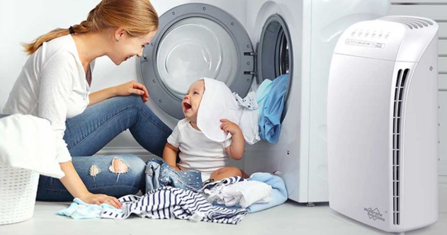 woman and baby sitting outside of dryer near air purifier