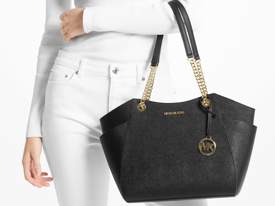 woman in a white outfit with a black and gold shoulder bag