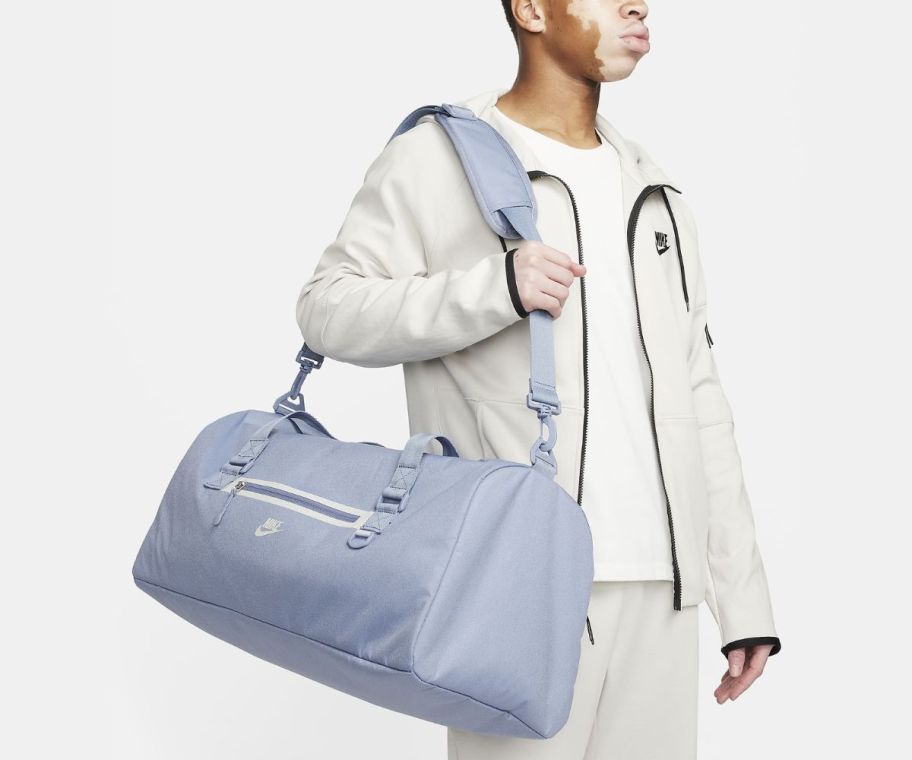 man carrying a light blue nike duffle bag