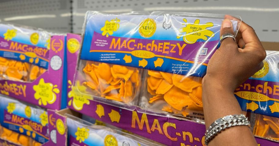 A person holding a Nuovo Mac-n-Cheezy Ravioli package in a store