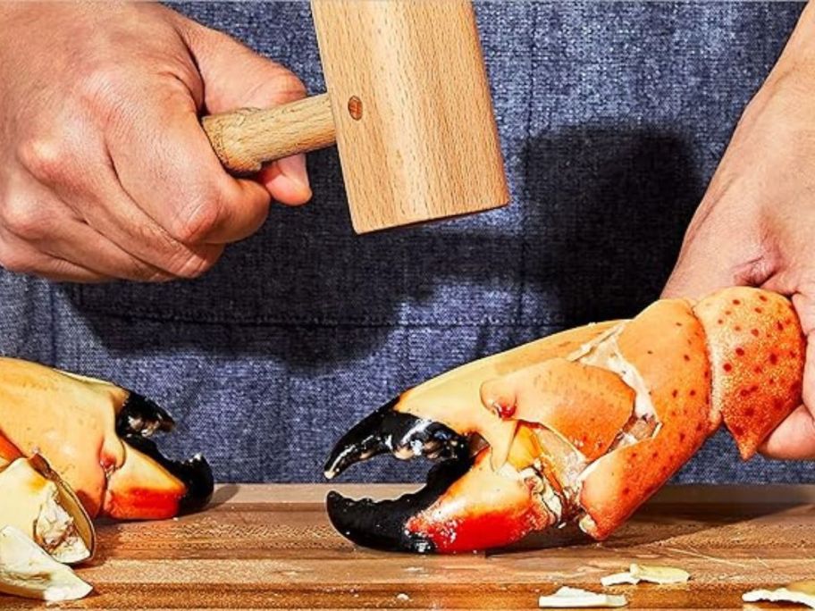 person using OXO Good Grips Wooden Seafood Mallet to crack crab claw