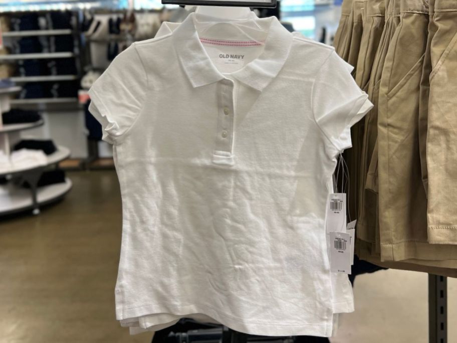 White old navy uniform polo shirt handing on a rack