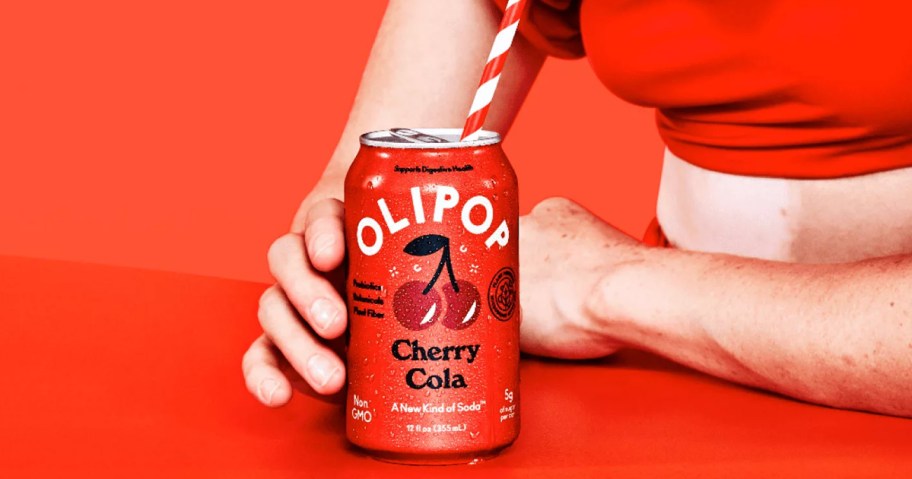 hand holding a red can of Olipop Cherry Cola