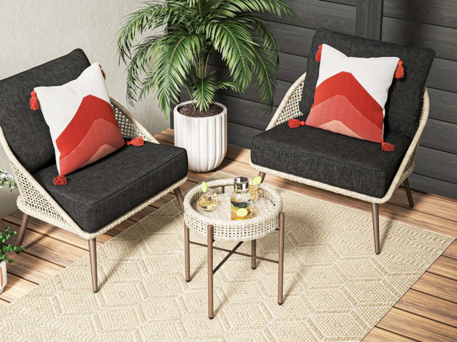 wicker patio chairs with black cushions and matching side table