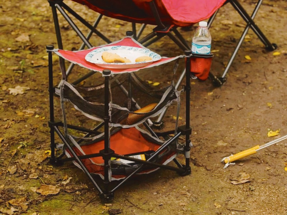 red and black 3 shelf camping table next to camp chair