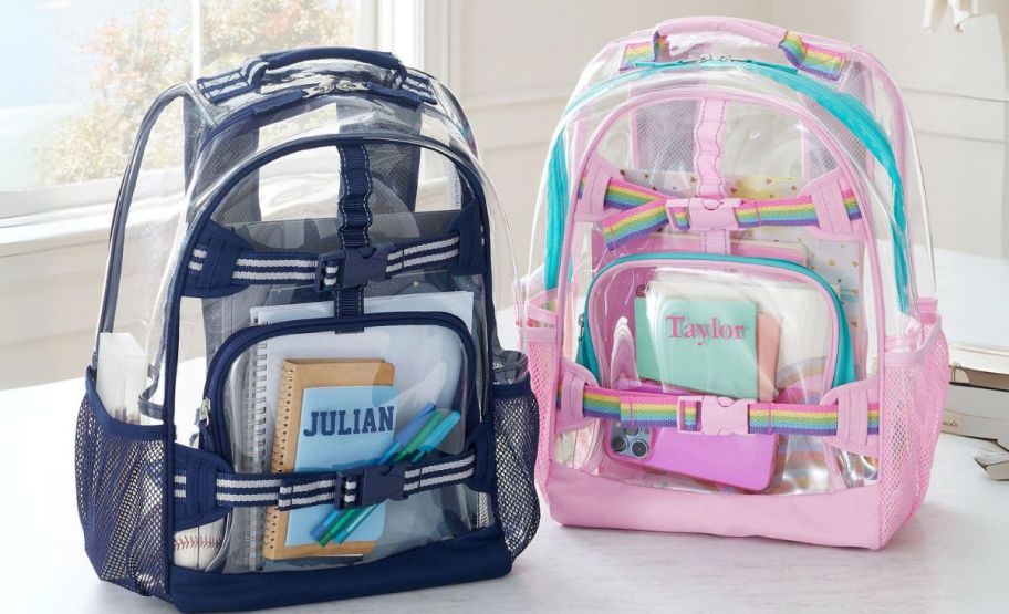 two clear backpacks, one with blue trim and one with pink