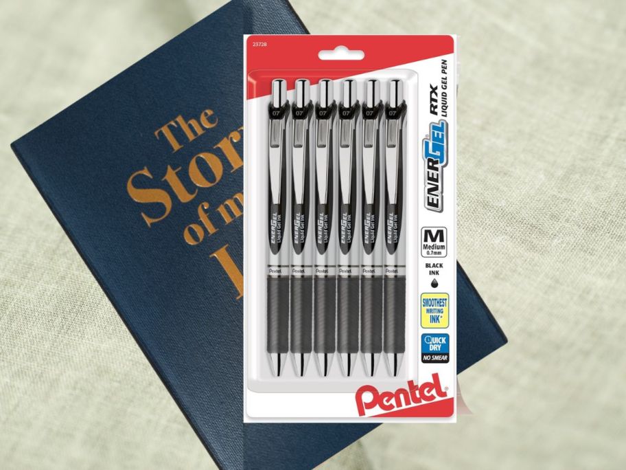 Pentel EnerGel RTX Retractable Liquid Gel Pen, (0.7mm), Medium Line, Metal Tip, Black Ink, Pack of 6 on book