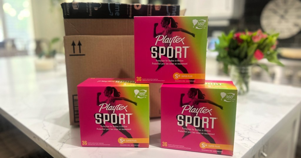 3 boxes of Playtex Sports Tampons in front of amazon box