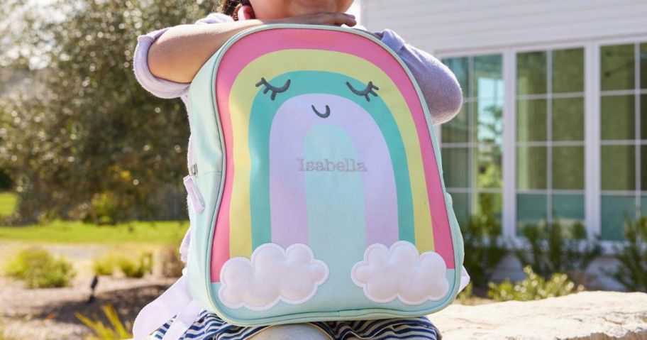 Girl holding a Pottery Barn Rainbow Backpack