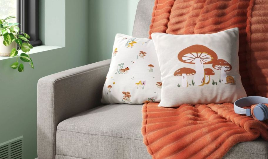 mushroom printed pillow 2 pack on a sofa with a green throw blanket