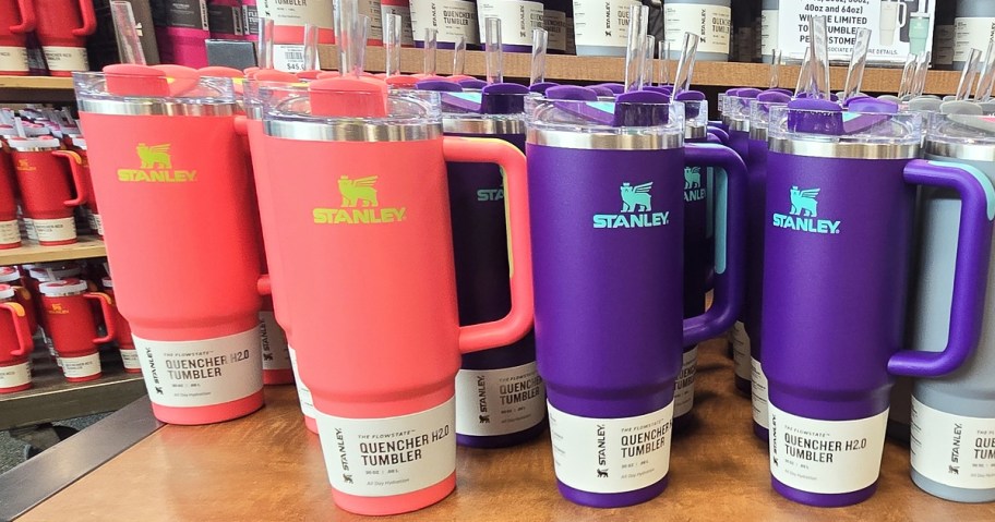 pink and purple stanley tumblers on store display table