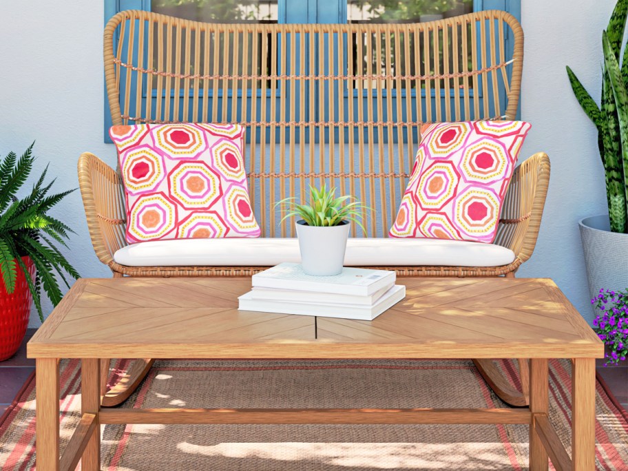 wicker patio chair with throw pillows and wood coffee table