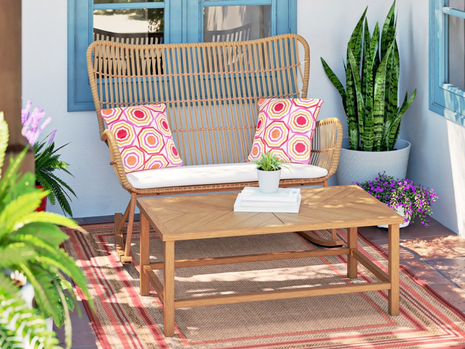 wicker patio chair with throw pillows and wood coffee table