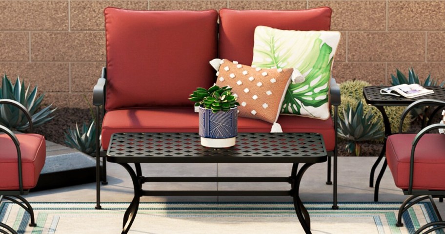 patio loveseat with red cushions and black coffee table