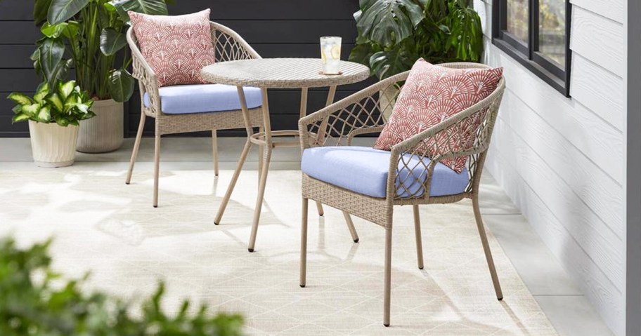 patio bistro set with blue cushions and red throw pillows