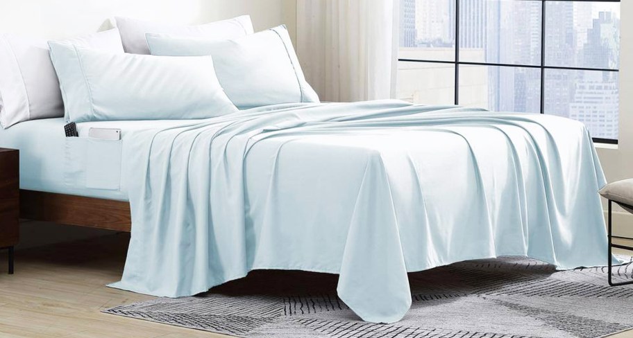 set of light blue sheets and pillows on a bed