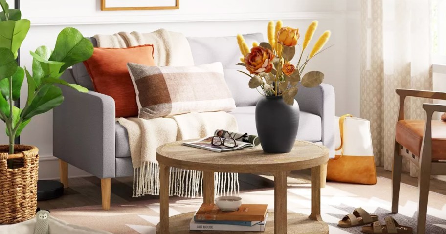 living room with grey loveseat and round wood coffee table