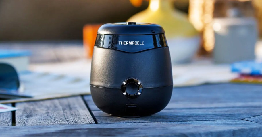 black thermacell sitting on wood outdoor table