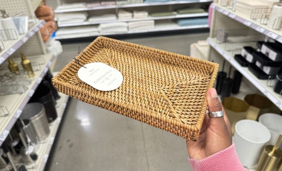 a womans hand holding a rattan tray