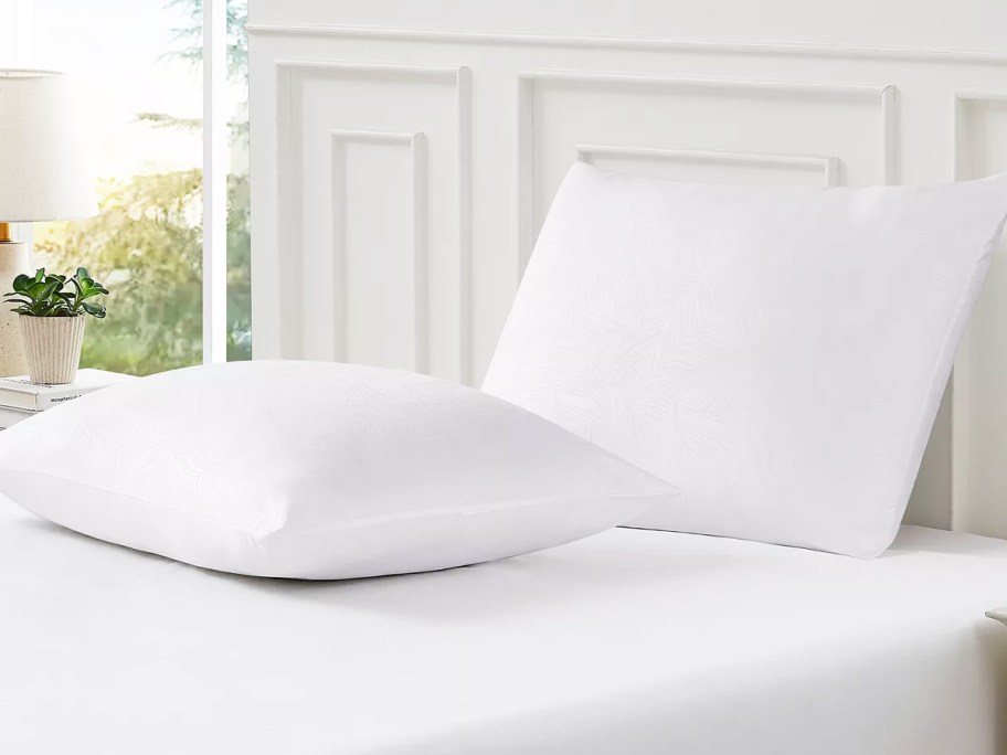 two white pillows on a bed