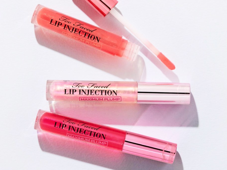 light pink, orange, and dark pink tubes of Too Faced Lip Injection Maximum Plump Lip Plumper
