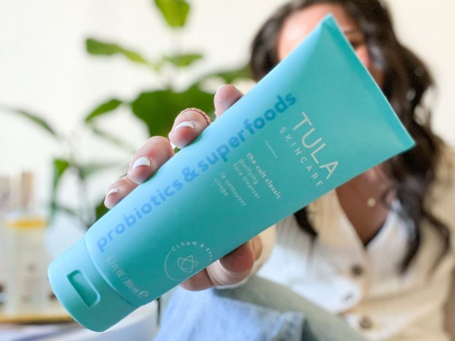 woman holding tula the cult classic purifying face cleanser