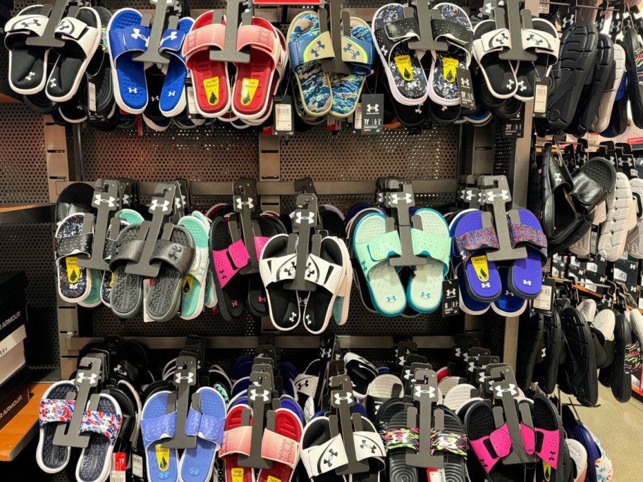 rows of Under Armour Slides hanging in store