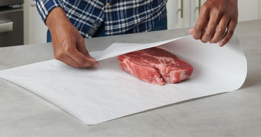 A man wrapping up a steak with Reynolds Freezer Paper