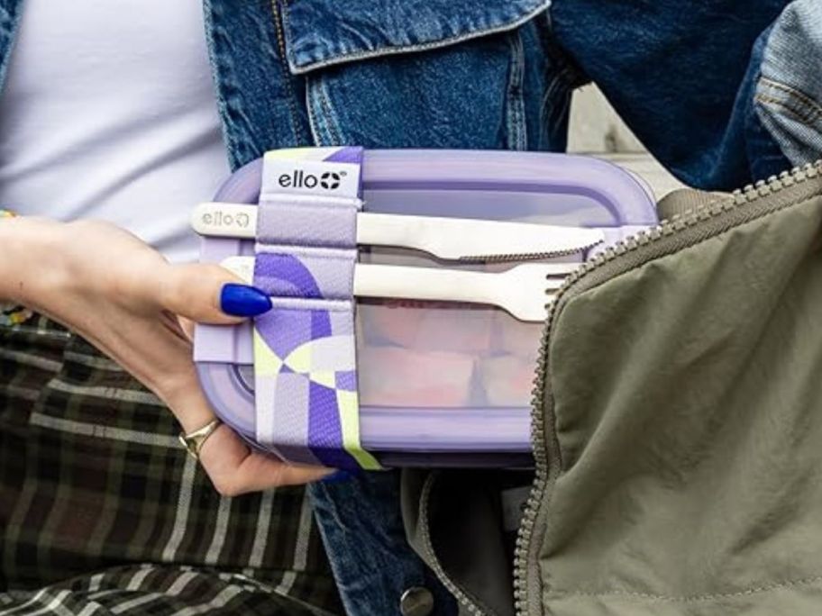 woman putting Ello 2-Pack Lunch Stack Plastic Food Storage Container into her bag