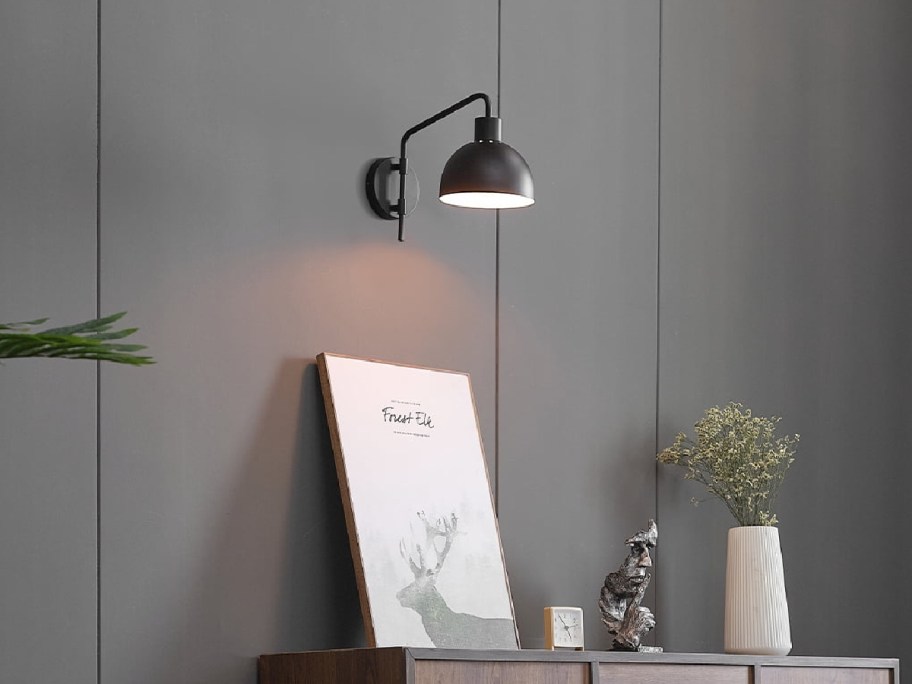 Wall sconce above a desk on top of items