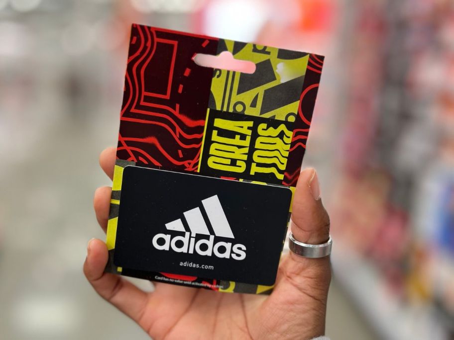 hand holding adidas gift card in store