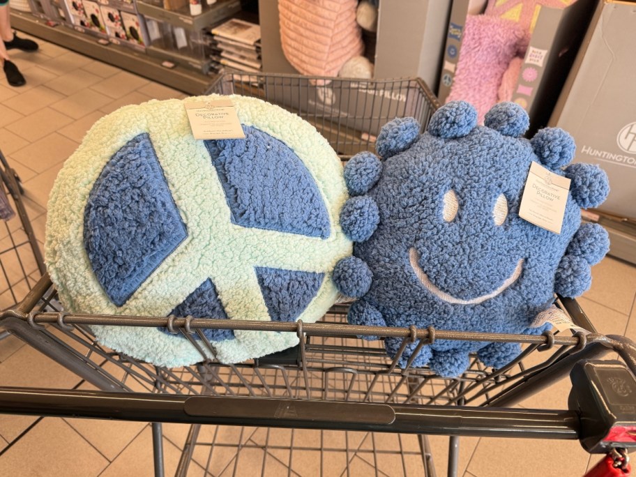 peace sign and smiley face throw pillows in a shopping cart