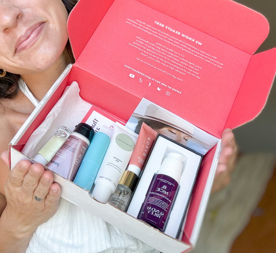 woman holding allure beauty box open with beauty items inside