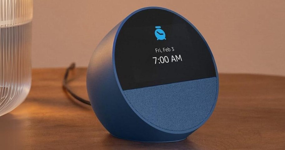 blue Amazon Echo device with a display showing an alarm clock symbol and the time