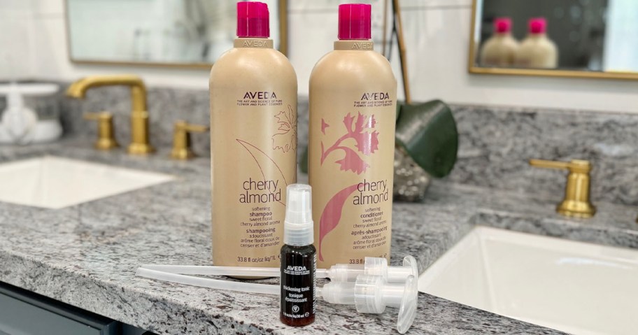 aveda shampoo and conditioner bottle with thickening tonic bottle on countertop