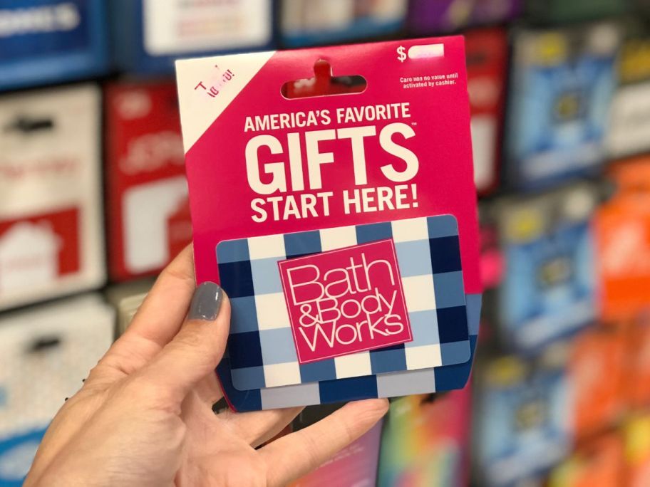 hand holding bath and body works gift card in store